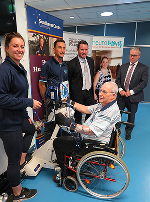Stroke survivor Murray Shergold receiving muscle stimulation from the RT300 Functional Electrical Stimulation Ergometer at NeuroMoves in Southern Cross University’s Health Clinic. Pictured l-r - Exercise Physiologists Kate Schaefer and Sam Mitchell, Graham Batten from Newcastle Permanent Charitable Foundation, and Southern Cross University’s Vice-President Global, Chris Patton.