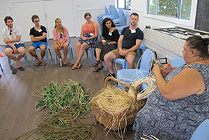 Sophie Wagner (centre, orange top) with fellow medicine students at the Indigenous orientation program organised by the University Centre for Rural Health. Here, they are learning to make fish traps with Bundjalung woman Monica Kapeen.