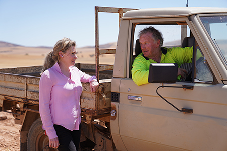 Dr Kate Gunn discussing the ifarmwell project with a farmer.